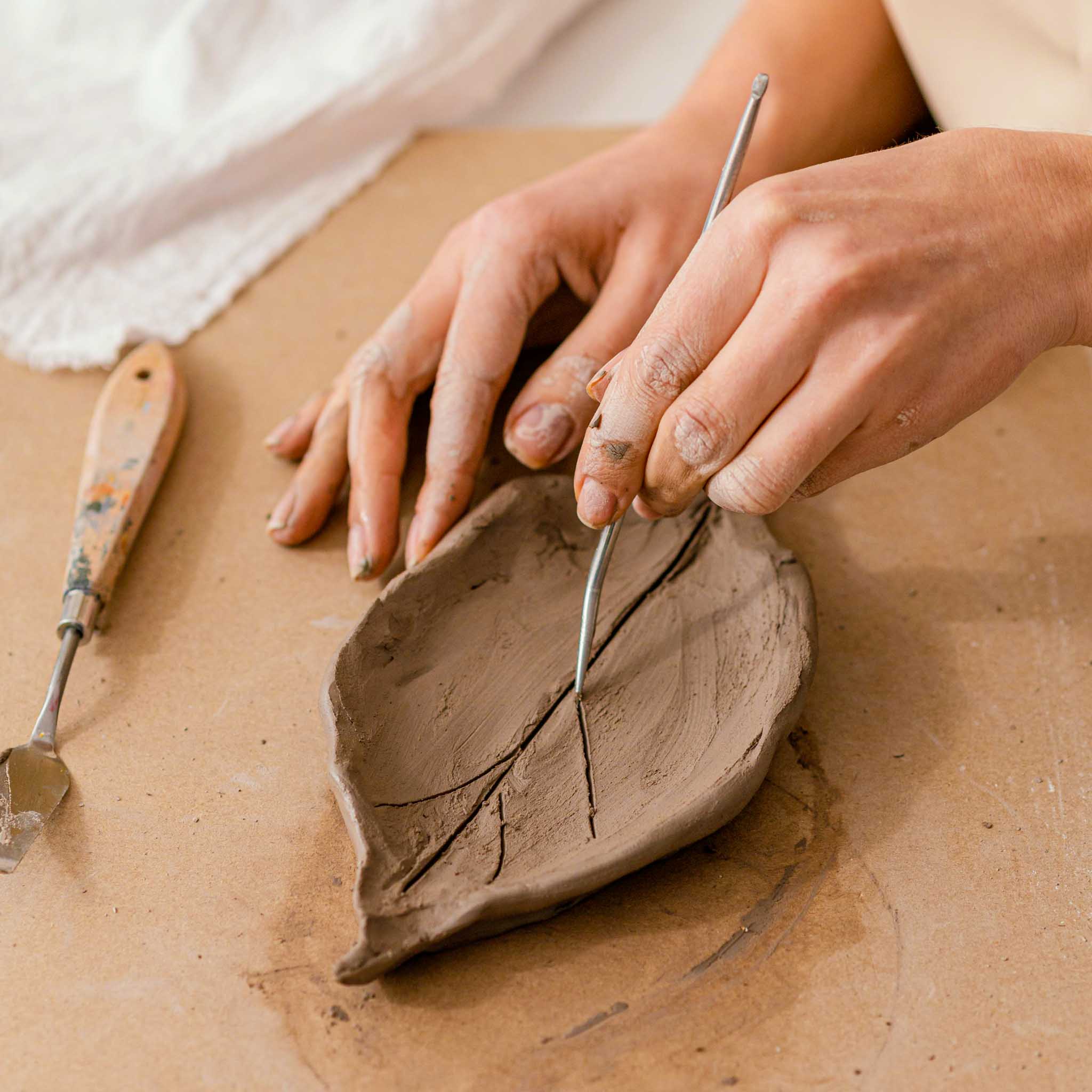 Create a functional ceramic item using traditional techniques such as pinching, coiling, or slab construction.
